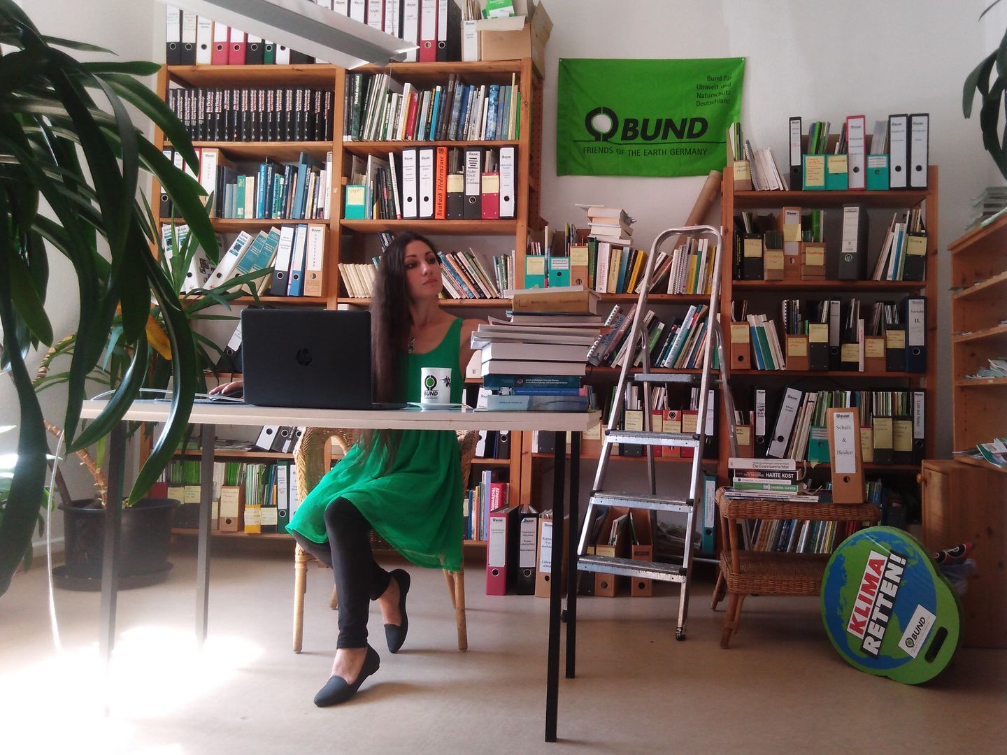 Eine Mitarbeiterin des BUND Nordschwarzwald sitzt vor einem riesigen Bücherregal am Laptop.